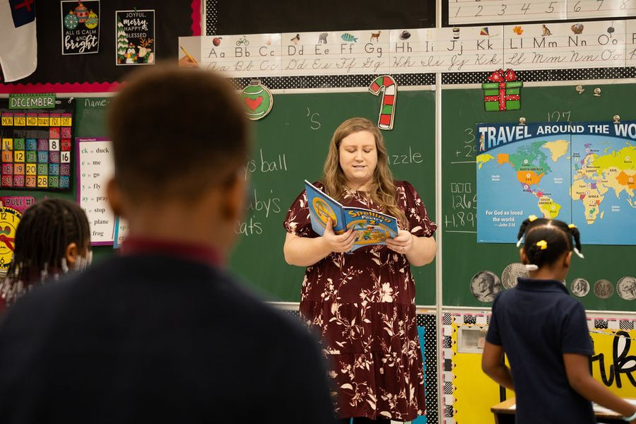 A teacher reads a book to her elementary class