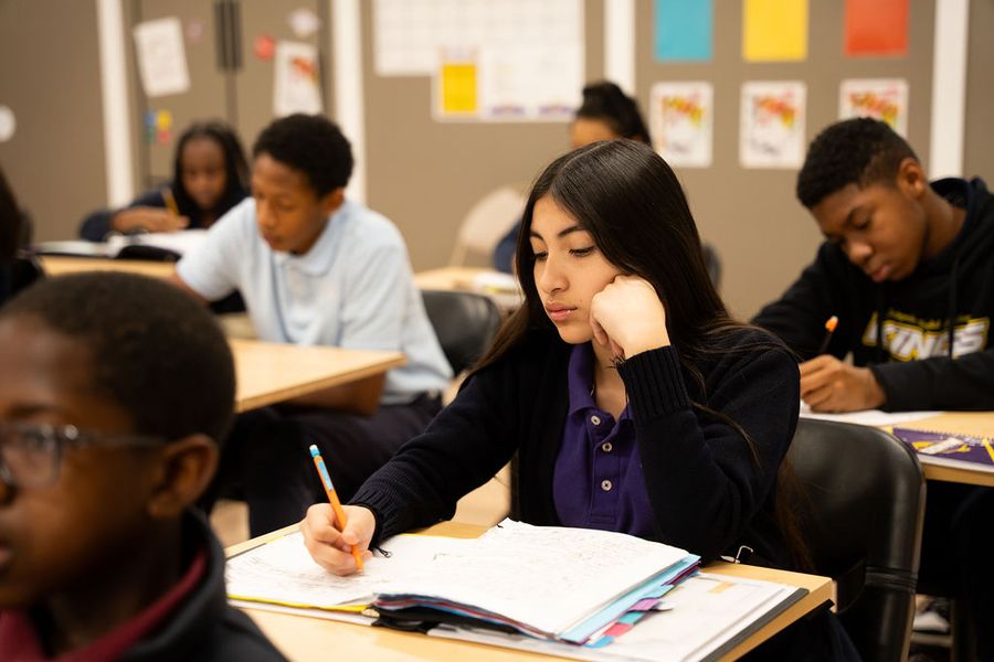 Junior high students taking notes in class