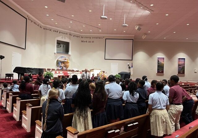 Students standing in the church sanctuary during chapel