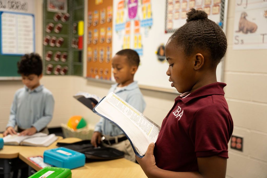 A student reads aloud from a book in class