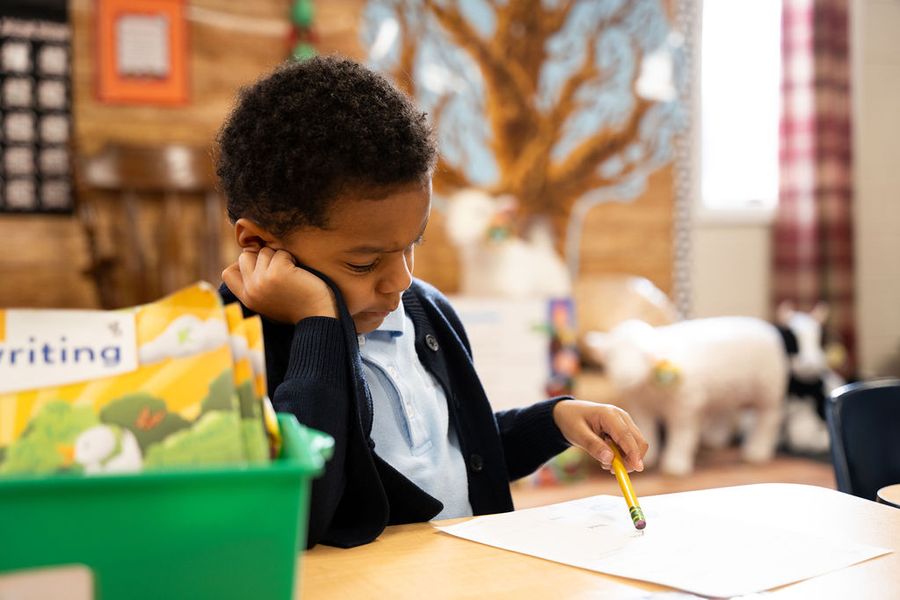 A young student writing at a desk